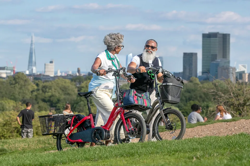 Couple walking up Primrose Hill in London with their Tern NBD e-bikes