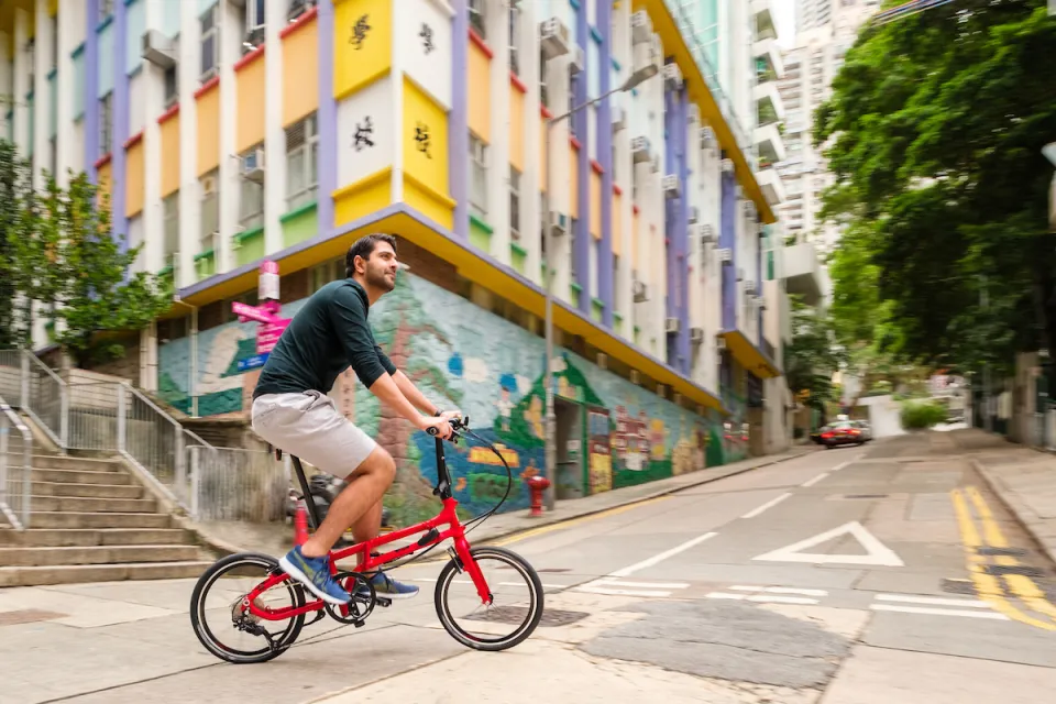 Man riding on a red Tern BYB P10 folding bike in Hong Kong.