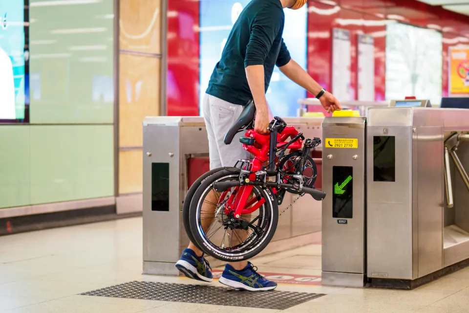 Man bringing the folded Tern BYB P10 folding bike onto the metro.