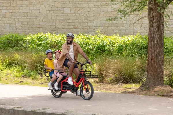 A father carrying his two kids on the Tern Quick Haul Long family ebike